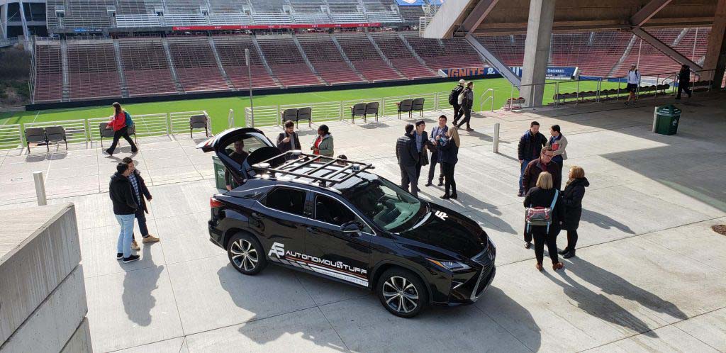 Autonomous vehicle inside a stadium with people around it